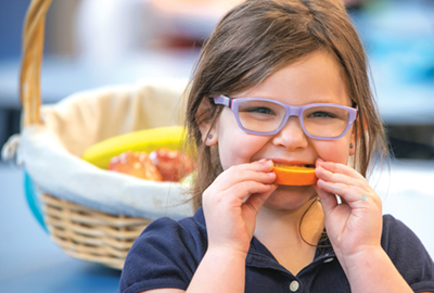 Jillian Fortney, a kindergarten student at St. Agnes School in Charleston, W.Va., eats an orange slice during lunch