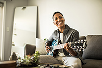 Man playing guitar on couch