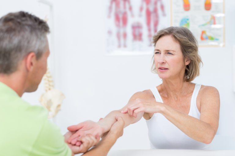 Doctor examining his patient's arm