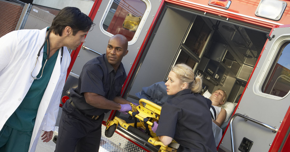 Doctor meeting two EMS workers as they take a patient out of an ambulance