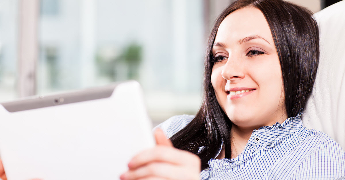 Young woman at home looking at a tablet computer device