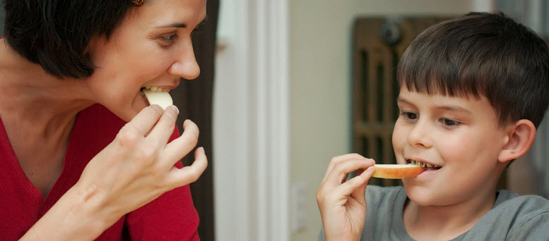 Woman and boy eating fruit