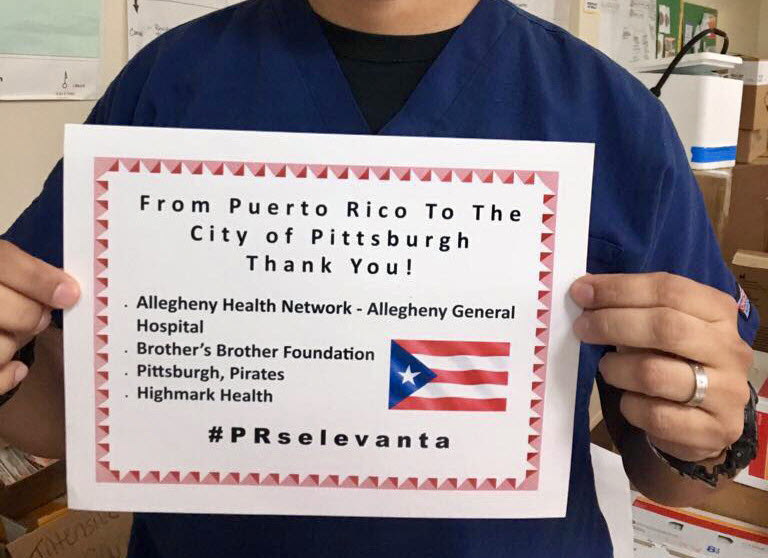 A doctor at the Centro Medico in Puerto Rico holds up a “thank you” sign after receiving much-needed medical supplies