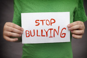A young boy holds Stop bullying sign