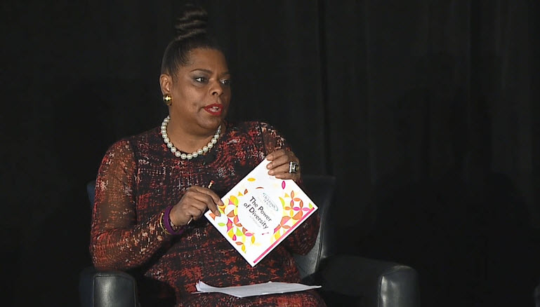 Yvonne Cook at Women’s Summit event holding program that says “The Power of Diversity”