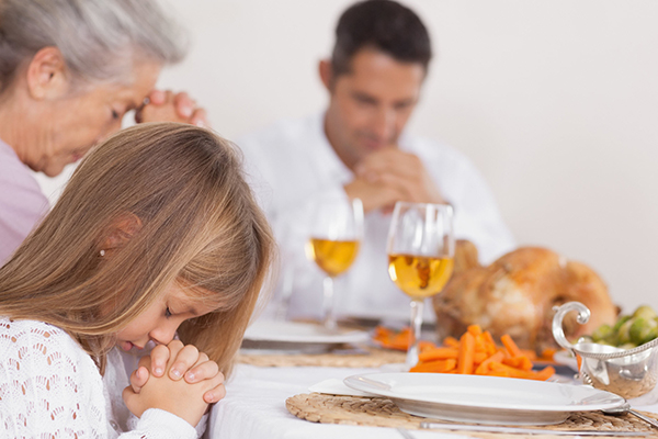 Family saying grace before dinner.