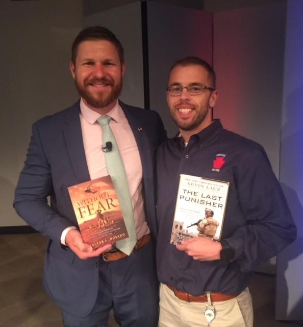 Kevin Lacz (left) and Walter Rosado (right) holding each other’s books.
