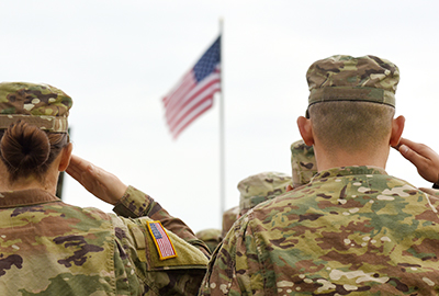 Proud saluting male army soldier on american flag background